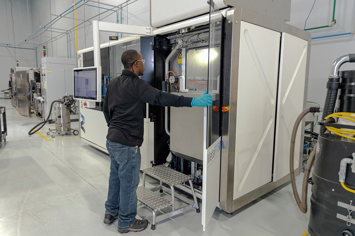 Machine operator opening a metal 3D printer